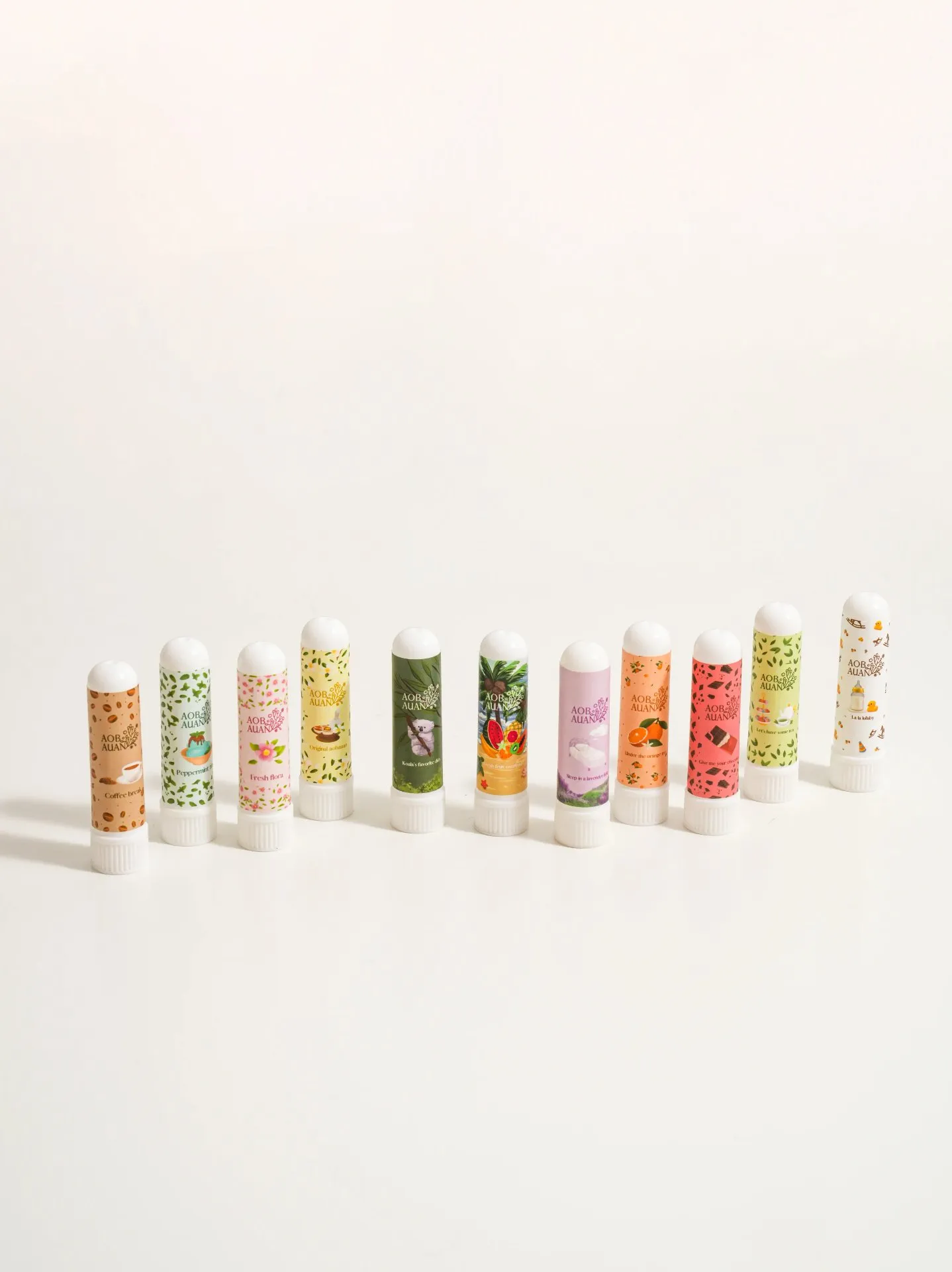 Eleven Aobauan Herb inhalers with illustrated labels standing in a row